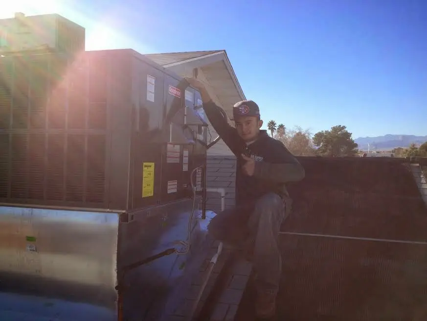 HVAC technician performing Heat Pump Repair on a rooftop unit in Bartlett